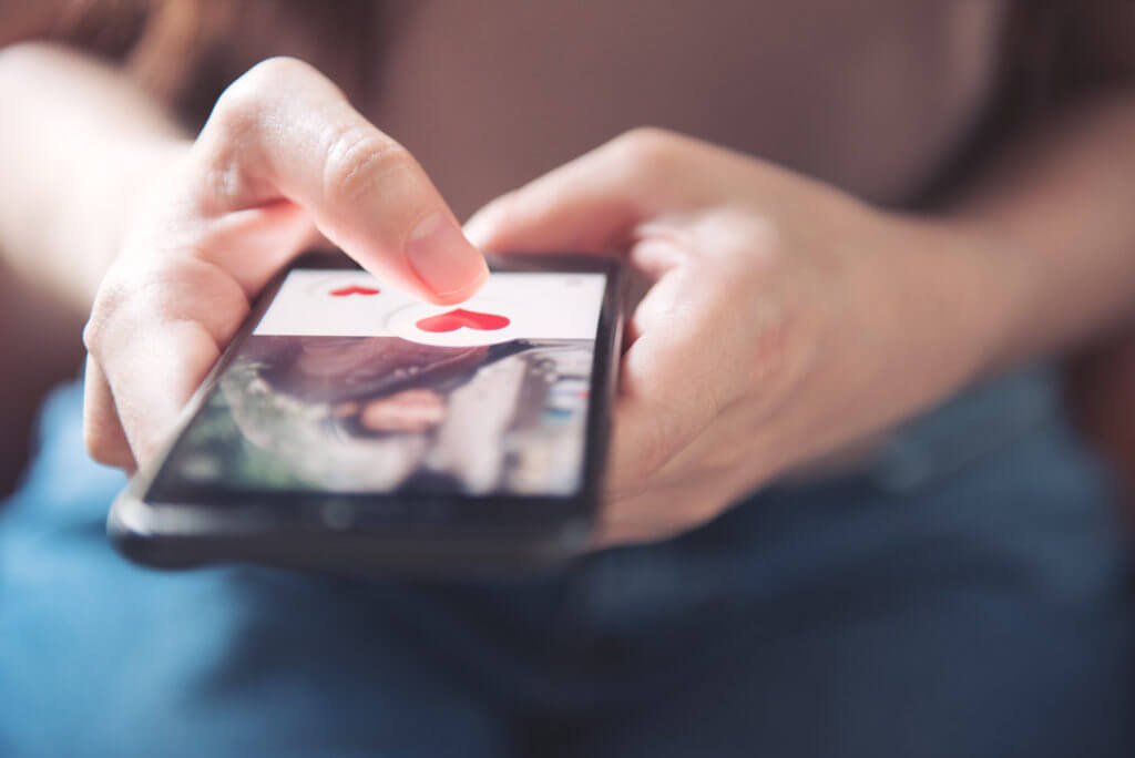 Woman Pushing Heart Icon on Dating App